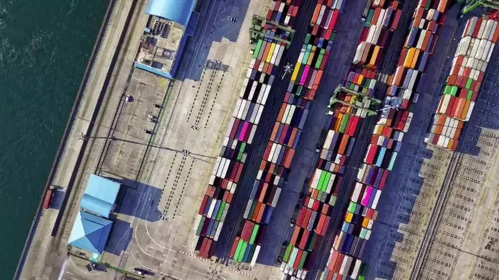 Aerial view of colorful shipping containers lined up at an international trade port