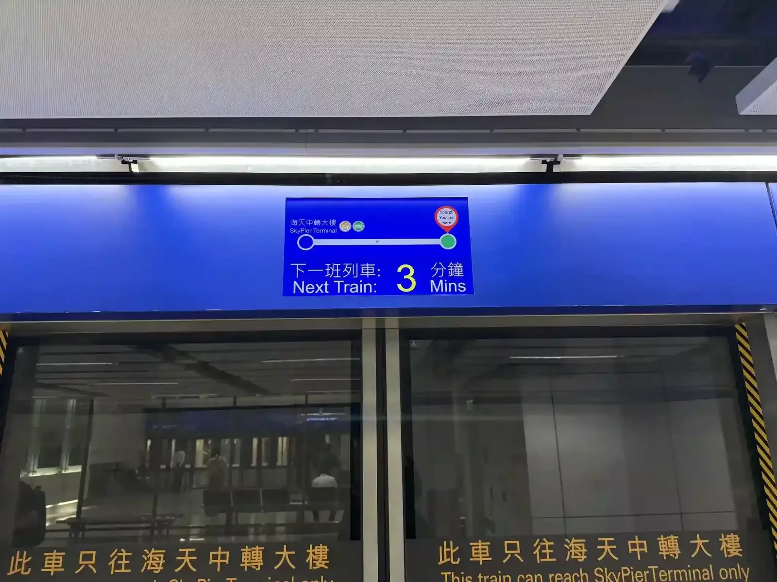 Digital display at train platform showing next train to Skypier Terminal